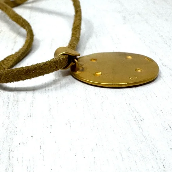 Mayan design gold tone pendant purchased in Costa Rica, on golden suede cord